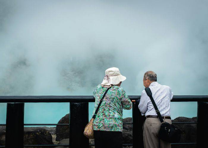 An old couple chatting while looking out at the steams of an onsen in Beppu.